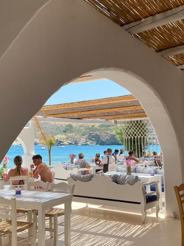 people are sitting at tables in an outdoor restaurant