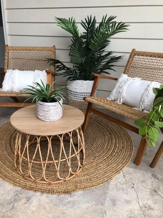 two chairs and a table with plants in them