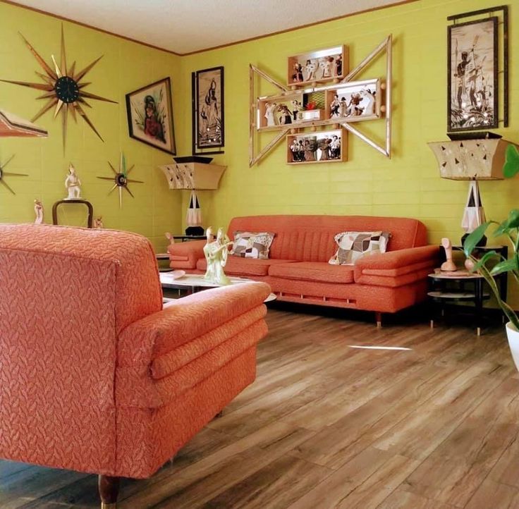 a living room with orange couches and pictures on the wall