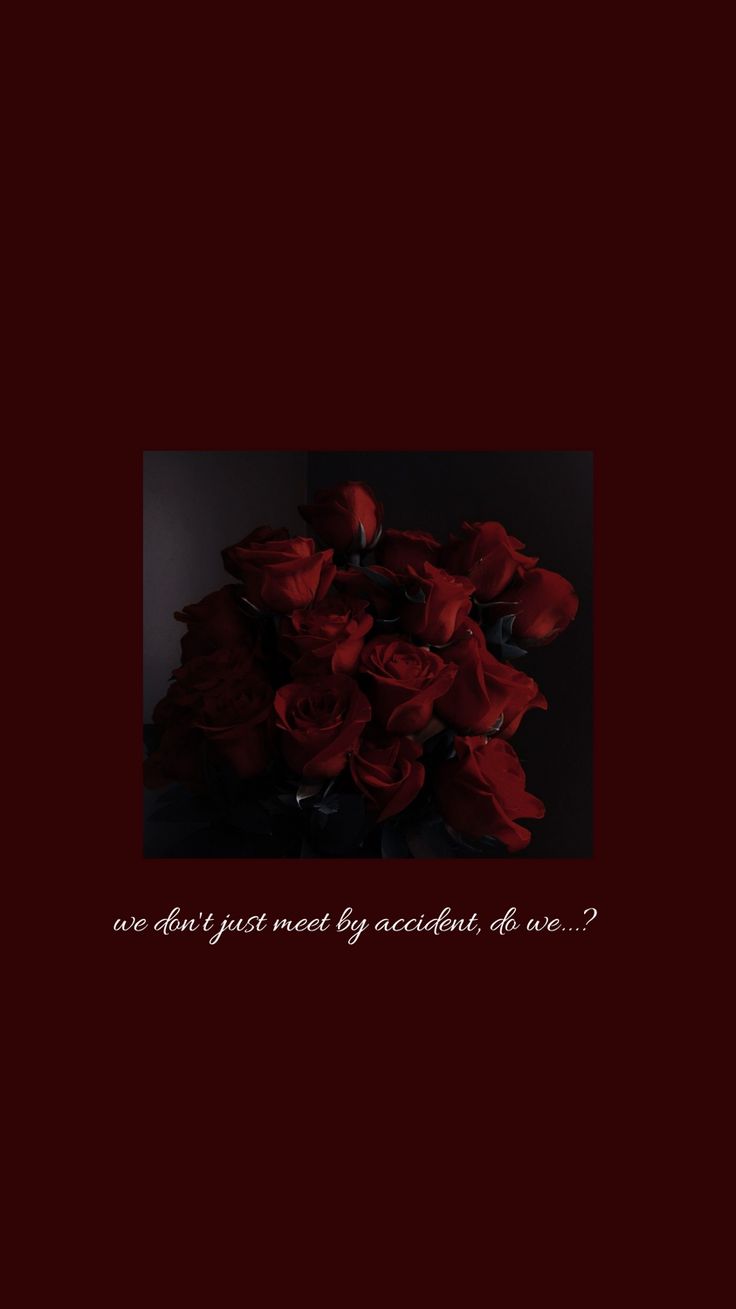 a bouquet of red roses sitting on top of a wooden table next to a black background