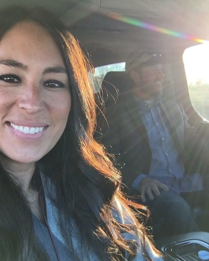 a woman sitting in the back seat of a car with a man standing behind her