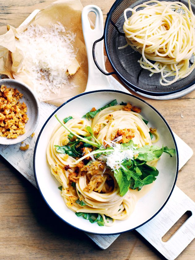 two bowls filled with pasta on top of a wooden table