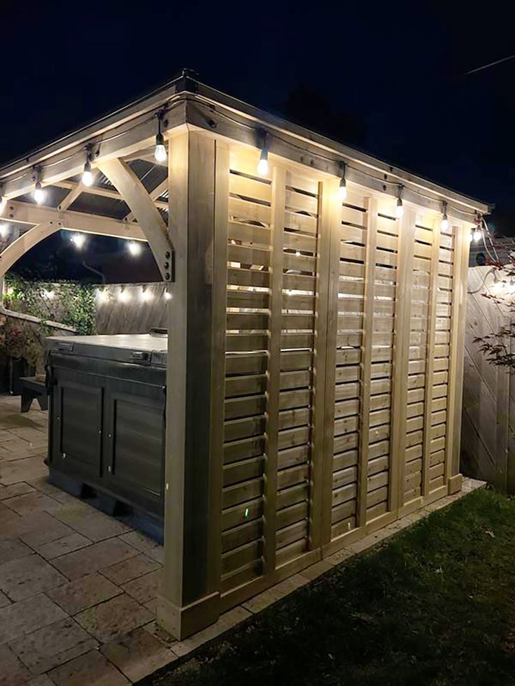 an outdoor hot tub in the middle of a yard at night with lights on it