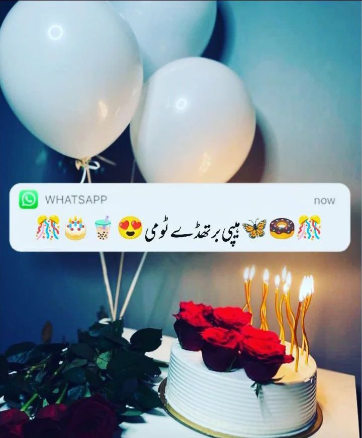 a birthday cake with candles on it and balloons in the background, which say whatsapp