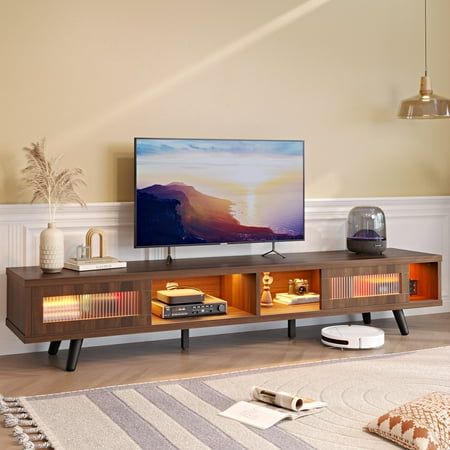 a flat screen tv sitting on top of a wooden entertainment center in a living room