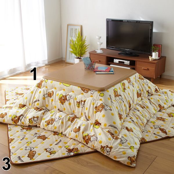 a living room with a couch, television and rugs on the floor in front of it