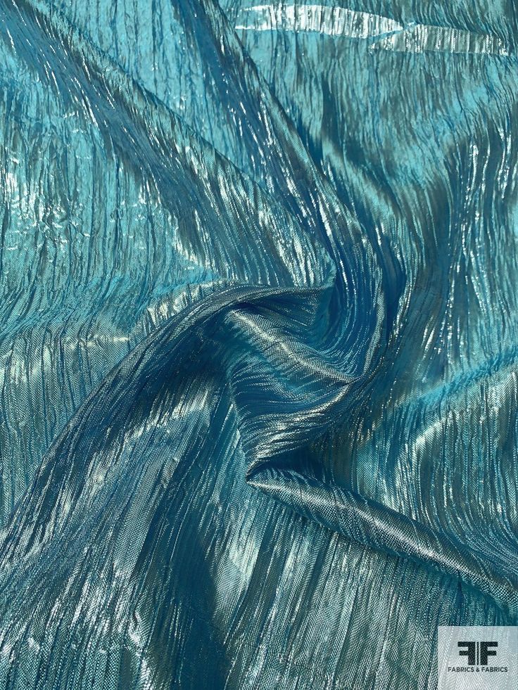 an image of blue and green fabric that looks like waves or lines in the water