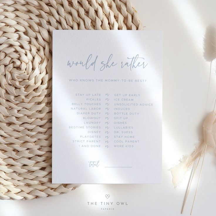 a white wedding program on top of a wicker table cloth next to some flowers