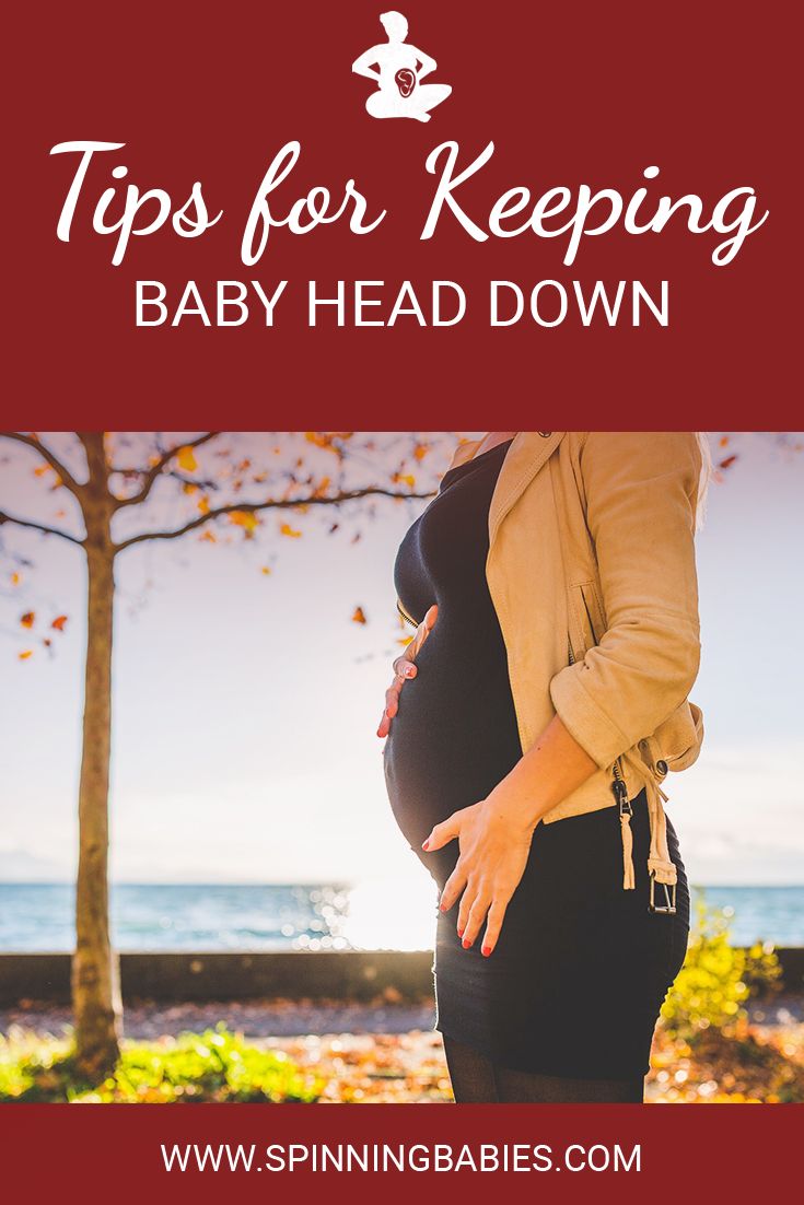 a pregnant woman holding her belly with the words tips for keeping baby head down on it