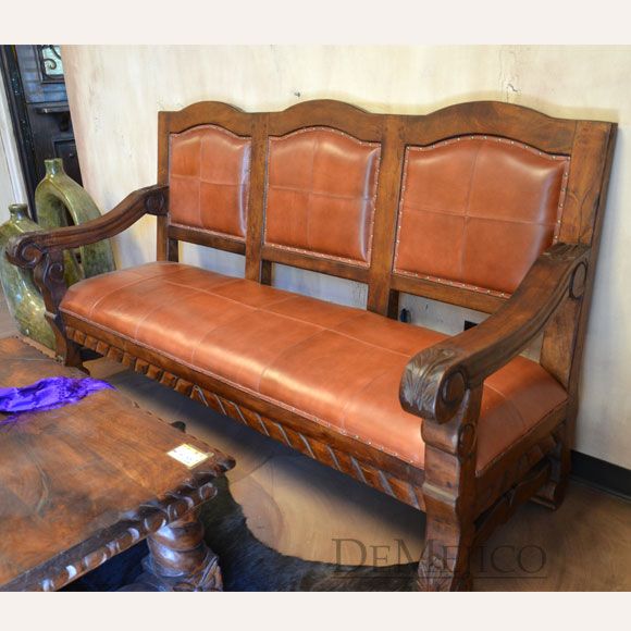 an old wooden bench with leather upholstered seats