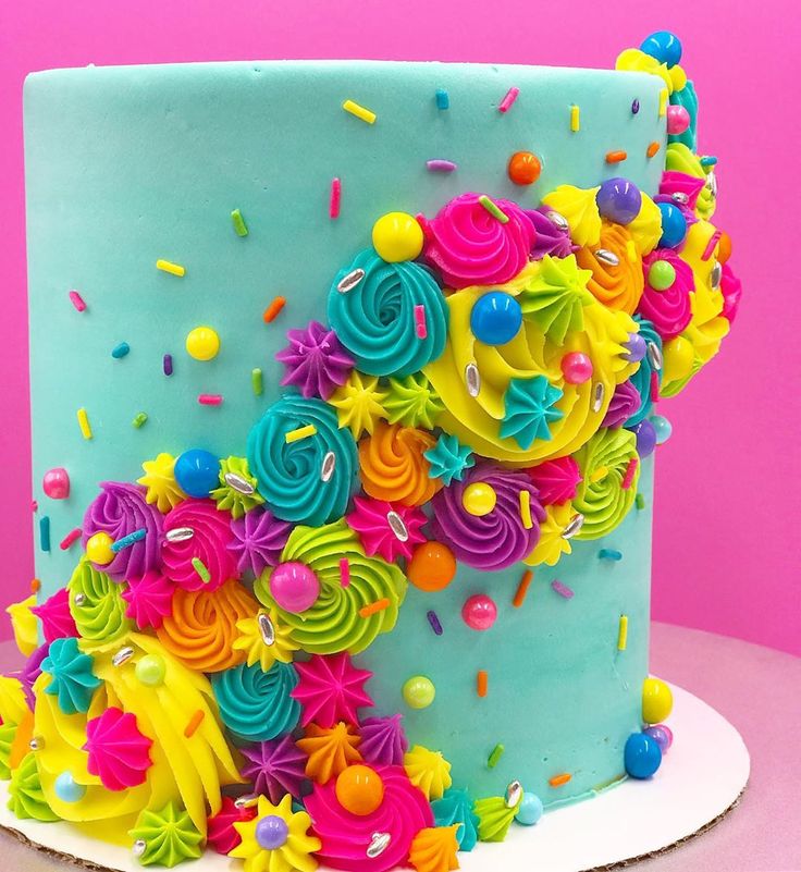 a brightly colored cake with sprinkles and confetti on the top