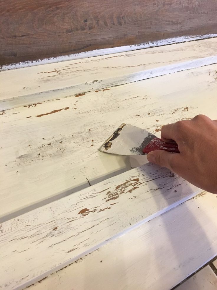 a person using a brush to paint white wood