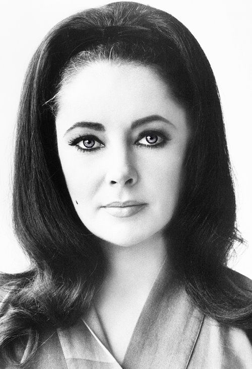 a black and white photo of a woman with long hair, wearing a collared shirt