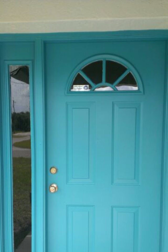 the front door is painted bright blue and has two sidelights on either side of it