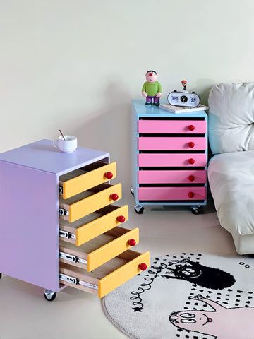 a child's bedroom with pink, yellow and purple drawers next to a bed