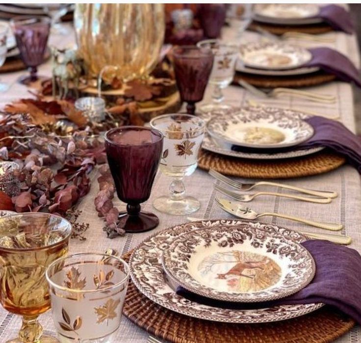 the table is set with plates, glasses and napkins for an elegant thanksgiving dinner