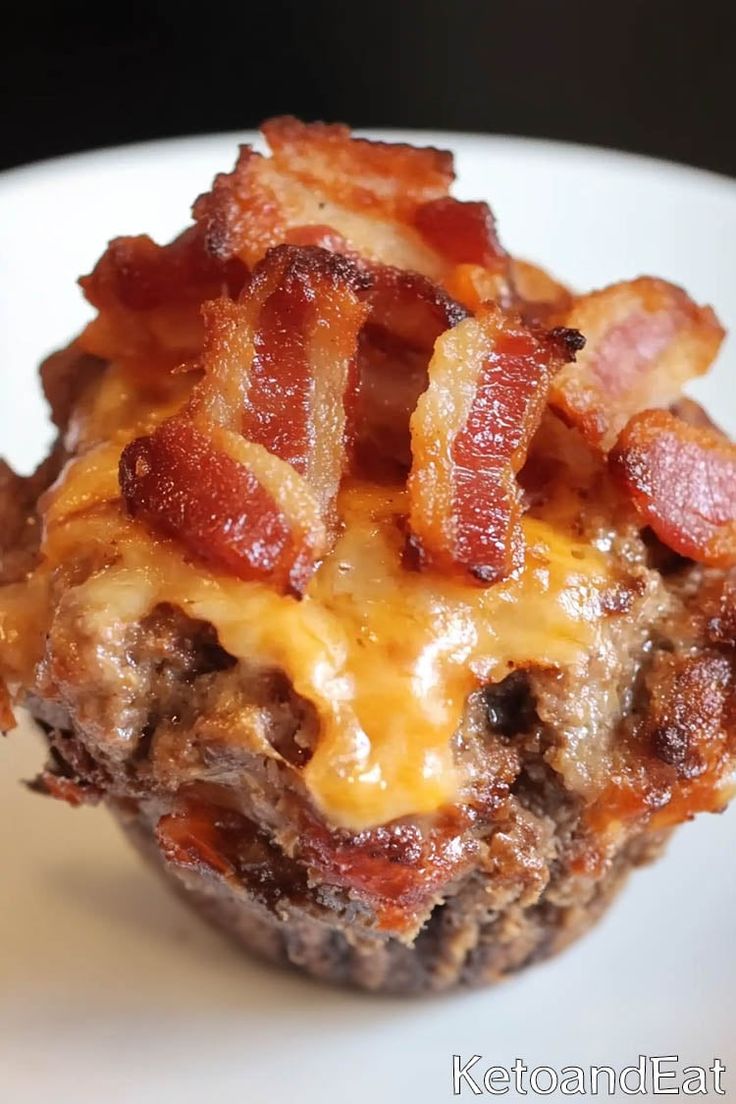 a bacon and cheese muffin on a white plate