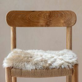 a wooden chair with a sheepskin seat pad