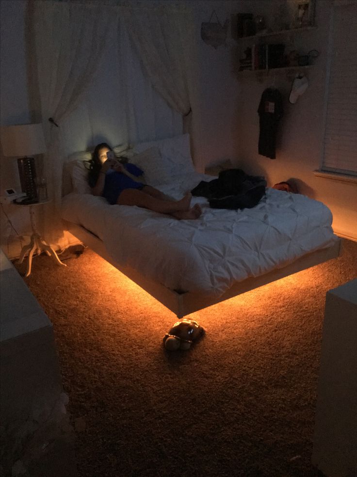 a person laying on a bed in the middle of a room with lights around it