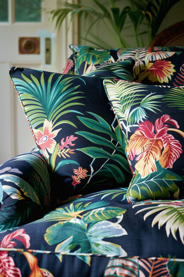 the pillows on the couch are covered with tropical print flowers and palm leaf designs,