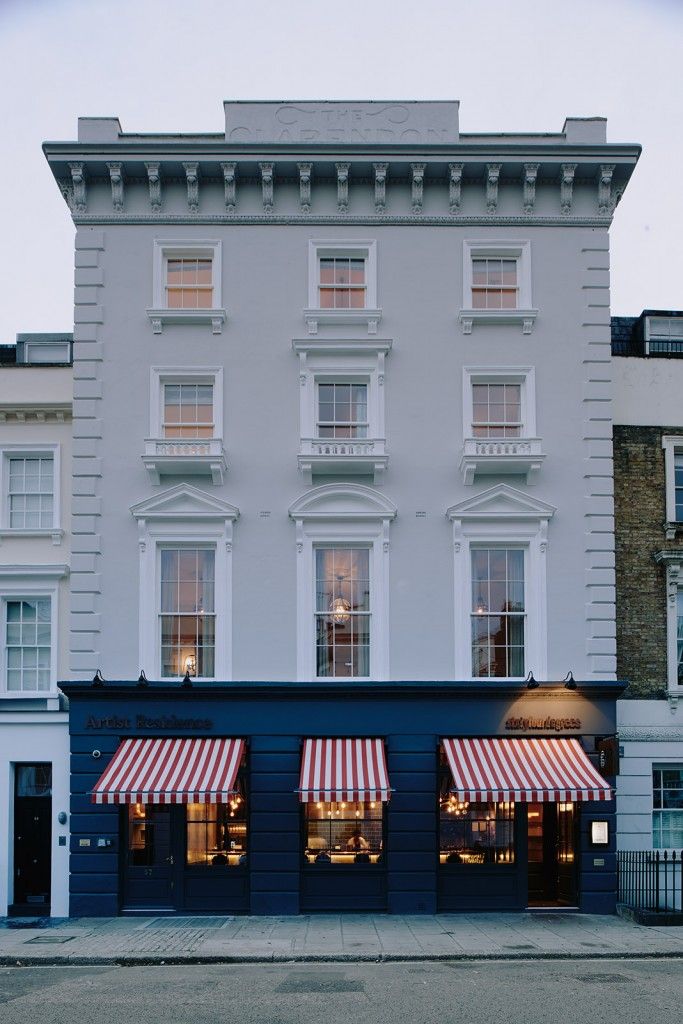 an empty street in front of a tall building with awnings on the windows