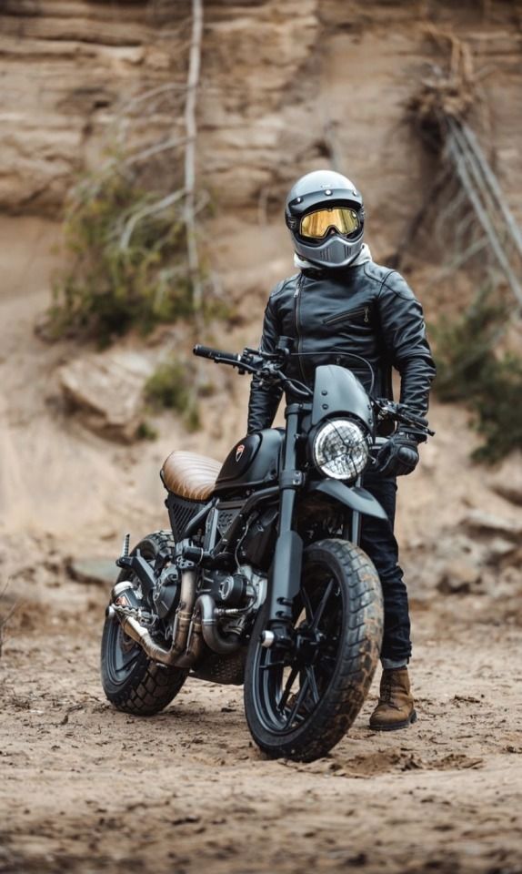 a man in black jacket and helmet sitting on motorcycle