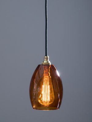 an orange light bulb hanging from a black cord on a gray wall with a white background