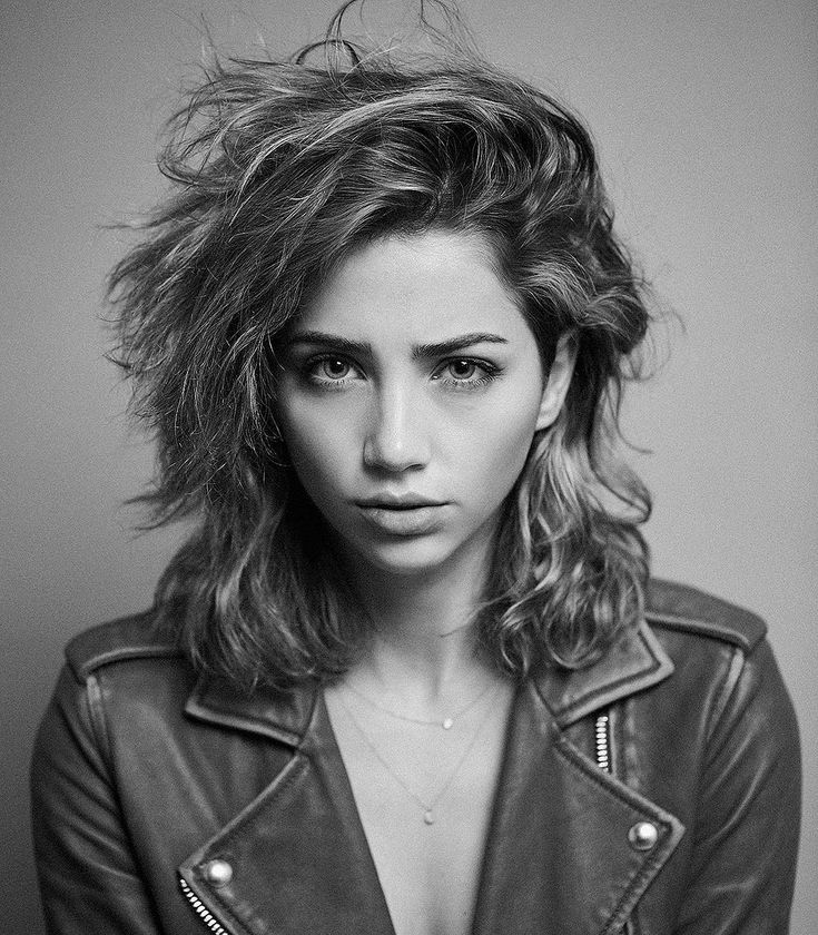 a black and white photo of a woman wearing a leather jacket