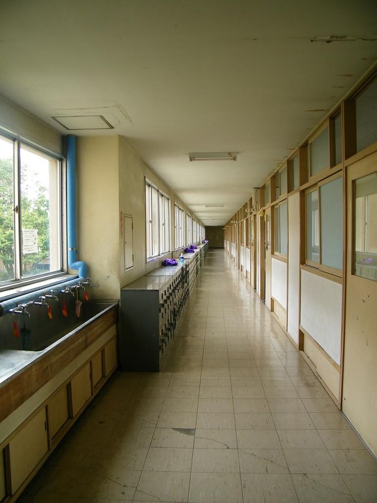 a long hallway with several sinks and windows