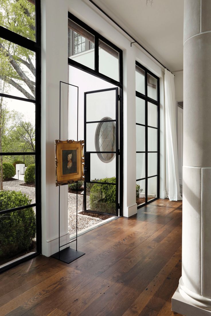 a room with wooden floors and large windows