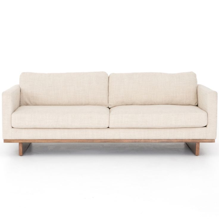 a white couch sitting on top of a wooden frame