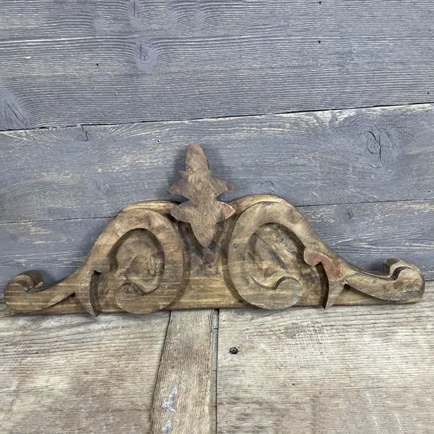 an old wooden corbge on the side of a wood planked wall with carvings