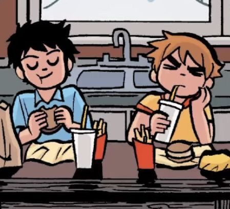 two children sitting at a table eating fast food