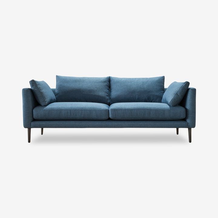 a blue couch with two pillows on it