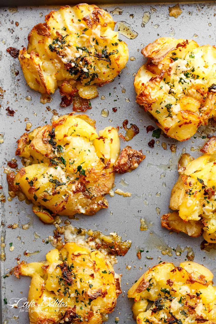 baked potatoes with cheese and herbs on a baking sheet