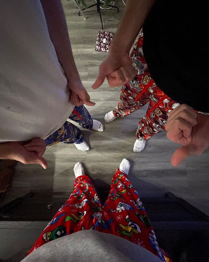 four people standing in a circle with their hands together