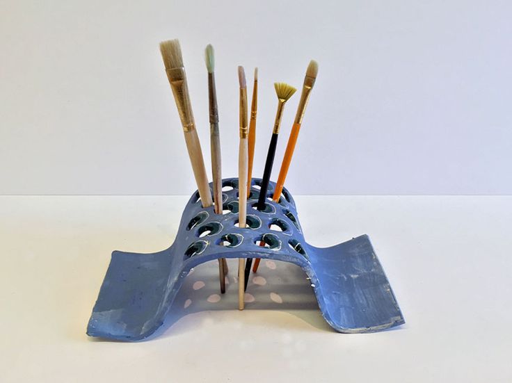 there are many brushes in the holder on the table