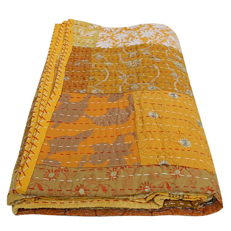 an orange and yellow blanket is laying on top of a white surface with the fabric folded over it