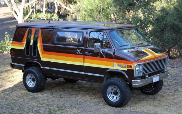 a van with orange and yellow stripes parked in the dirt