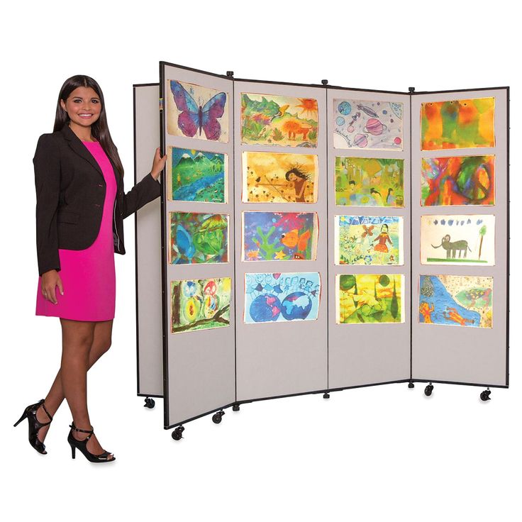 a woman in a pink dress standing next to a room divider with pictures on it