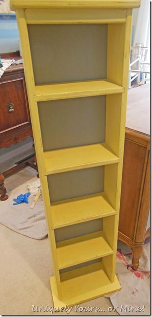 a yellow book shelf sitting in the middle of a room