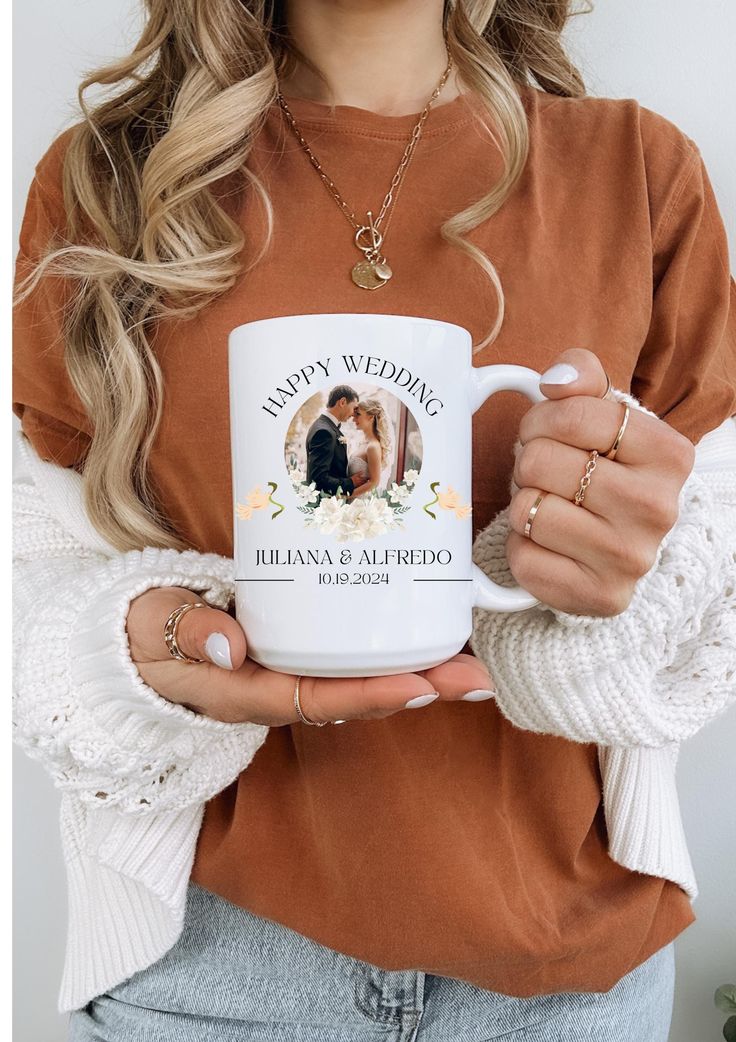 a woman holding a coffee mug in her hands with the words happy wedding on it