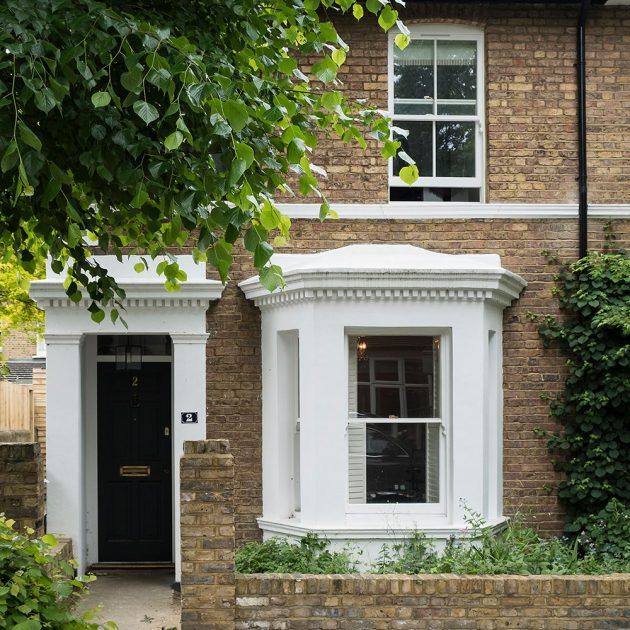 a brick house with white trim and black door