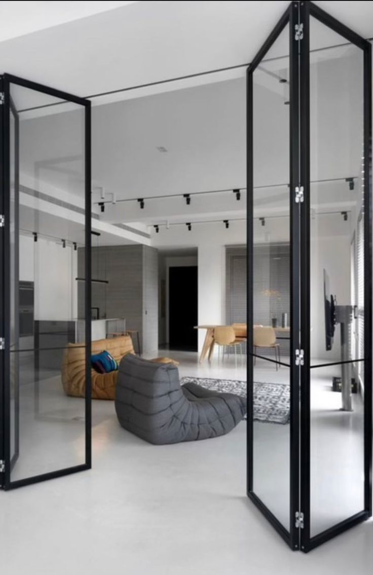 an open room with glass walls and furniture