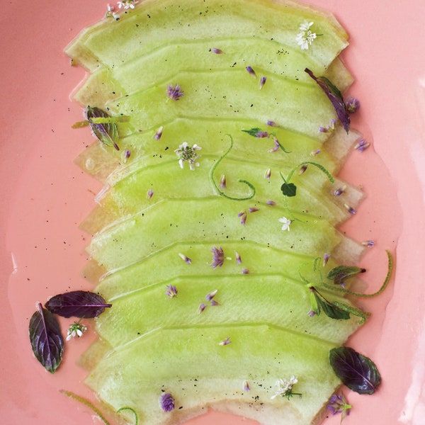 a pink plate topped with sliced up green vegetables