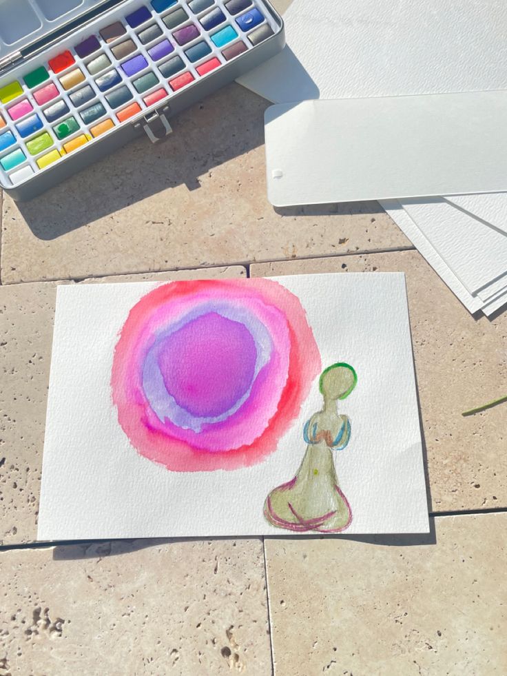 a watercolor painting on paper next to some paintbrushes