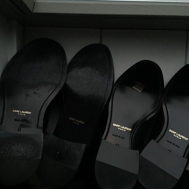 five pairs of black shoes are lined up in a row on the shelf next to each other