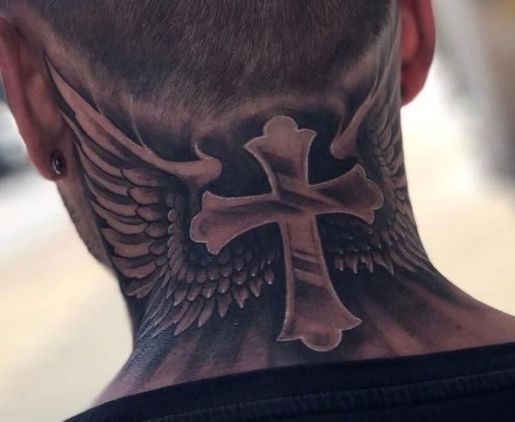 the back of a man's head with a cross and wings tattoo on it