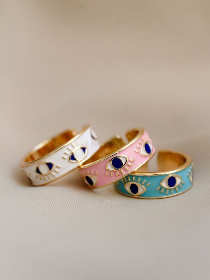 18k Gold Plated E-Coated Brass & enamel Adjustable sizing, one size fits most Each color sold separately Gold Enamel Hand Painted Rings, Hand Painted Gold Enamel Rings, Hand Painted Enamel Gold Rings, Blue Enamel Fine Jewelry Ring, Blue Enamel Ring Fine Jewelry, Blue Enamel Ring In Fine Jewelry Style, Trendy Yellow Gold Enamel Jewelry, Pink Enamel Stackable Jewelry, Blue Stackable Enamel Ring