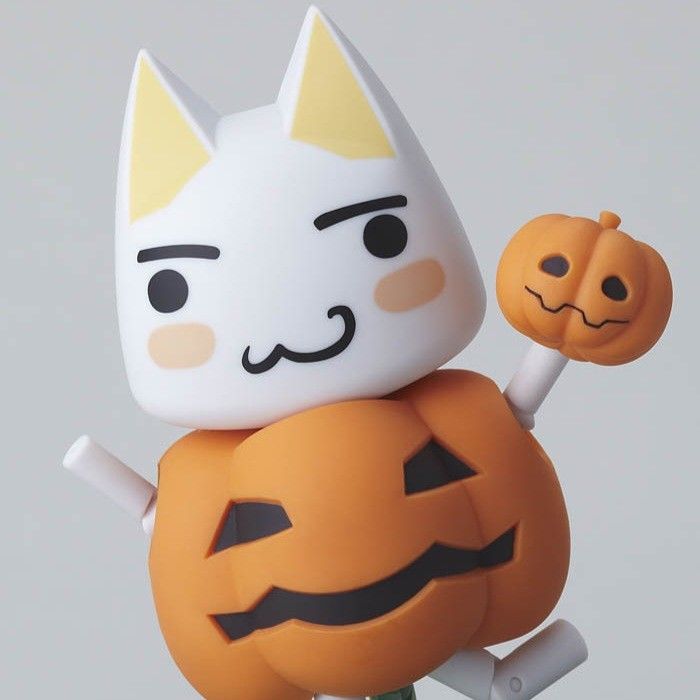 a cat figurine holding a jack - o'- lantern on top of a pumpkin